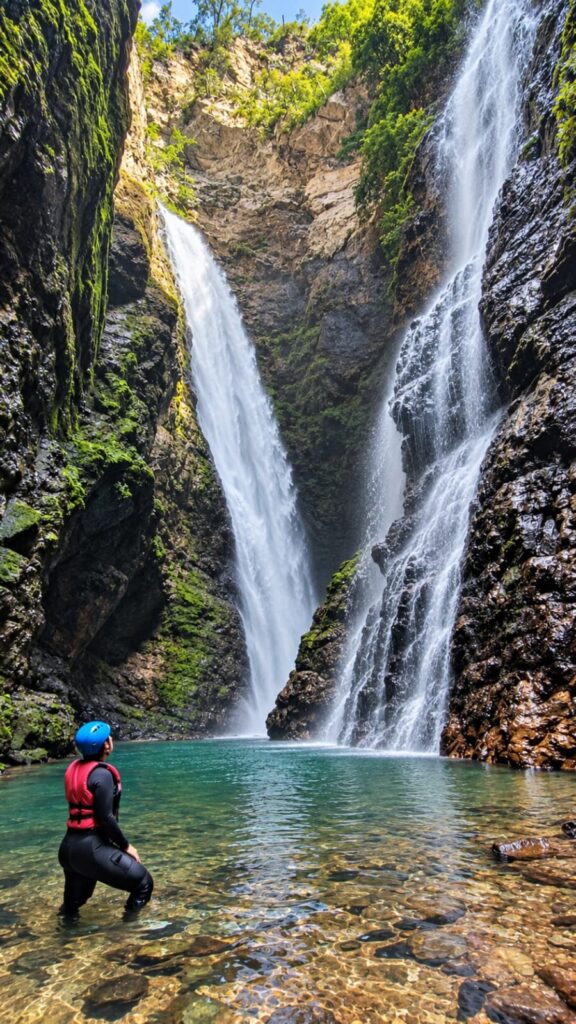 Visitante com roupa de neoprene, colete salva-vidas e capacetes contempla as quedas d'água da Cachoeira do Dragão, na Chapada dos Veadeiros, em meio a paredões rochosos e águas cristalinas